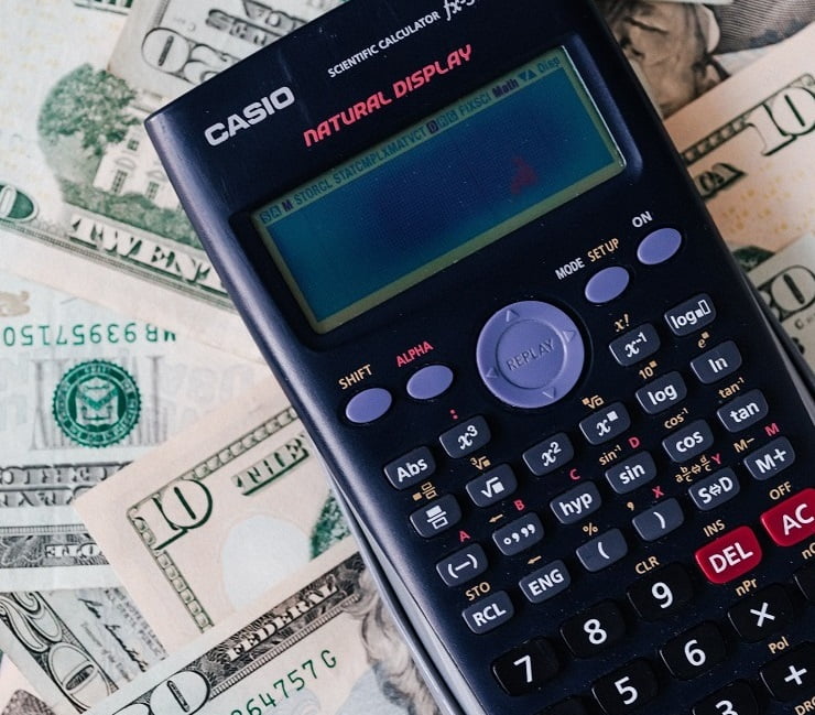 a calculator on cash money as symbol of payroll services in & near Bronx, NY