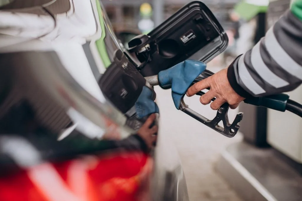 An old man filling the fuel tank with gas in and near Bronx, Ny