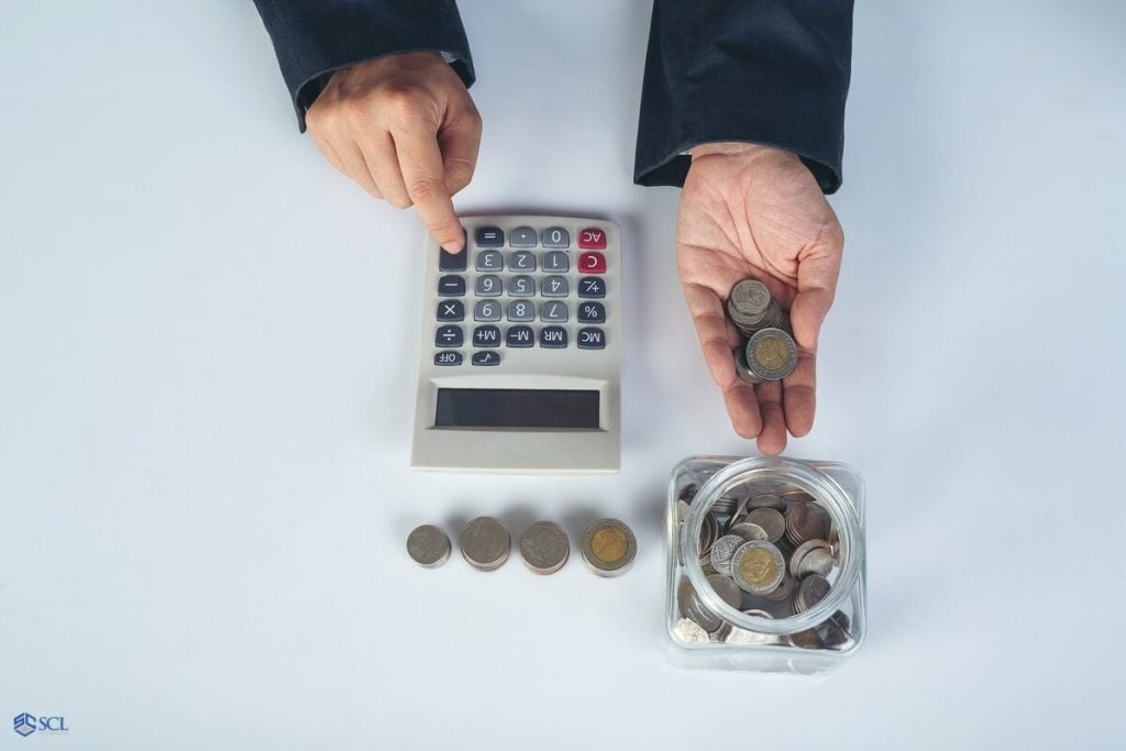 Using a calculator and coins to do your own taxes as a business owner