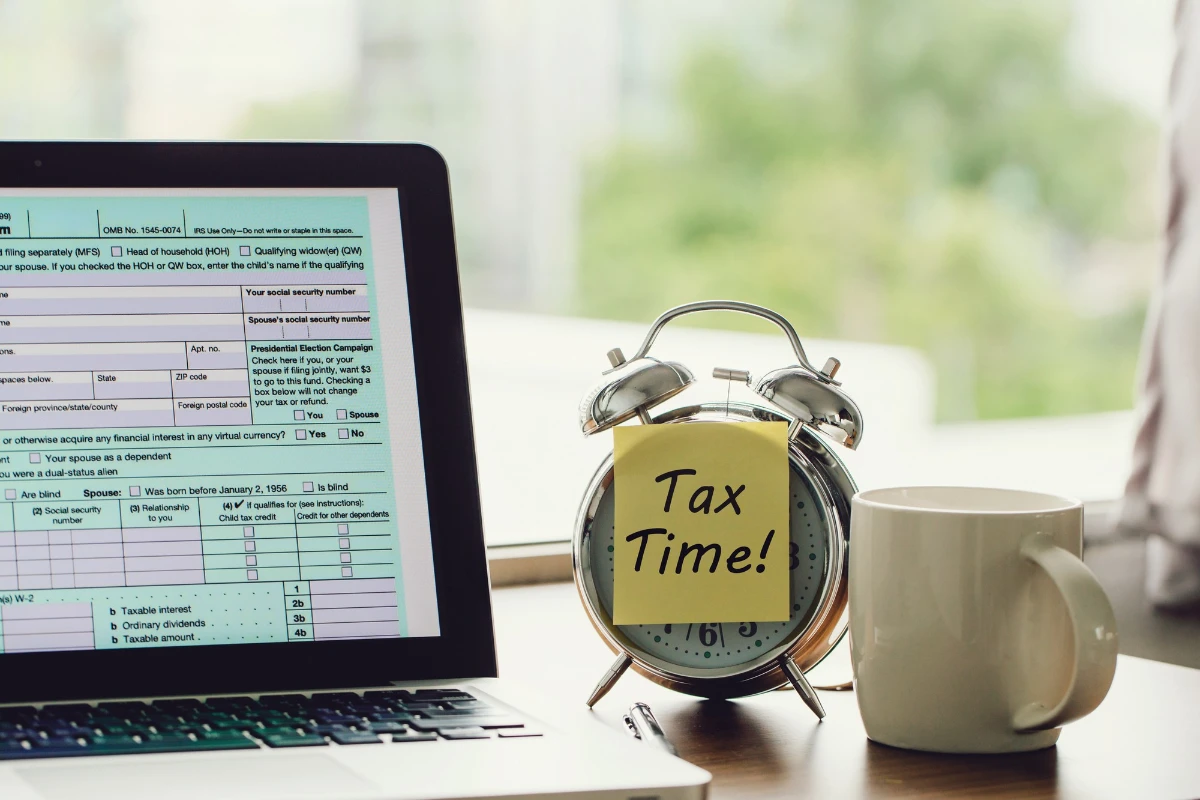 Tax time concept tax time on a postit on alarm clock and Individual income tax return form online