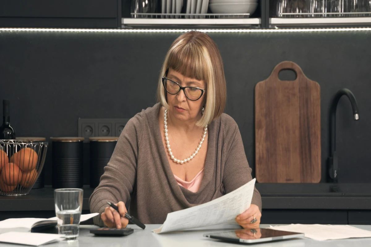 Senior woman filing a tax extension in the kitchen.