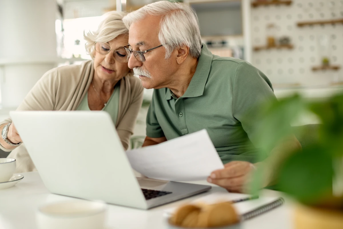 Senior couple reviewing documents together, discussing their tax benefits related to retirement planning.