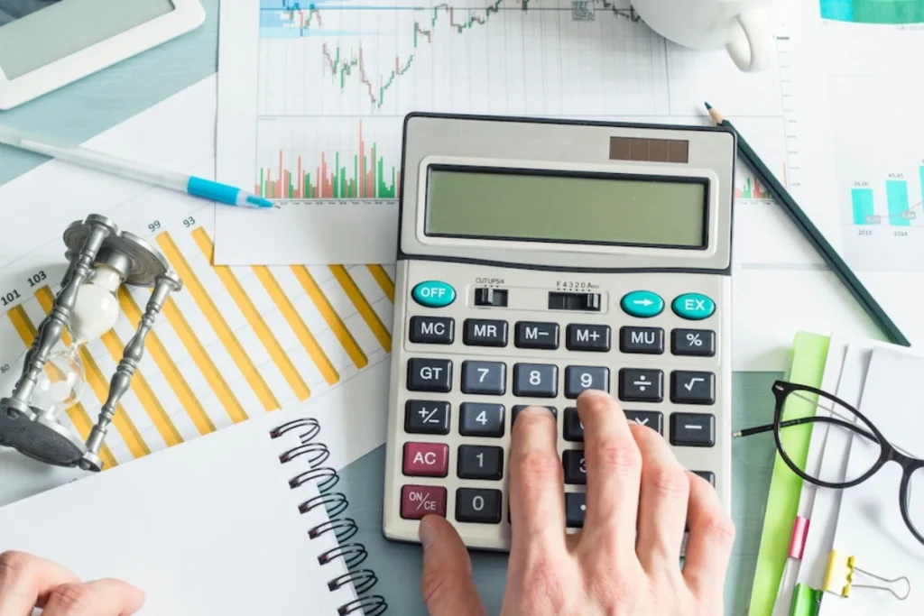 Hands of a business man preparing a financial report and working at a calculator.
