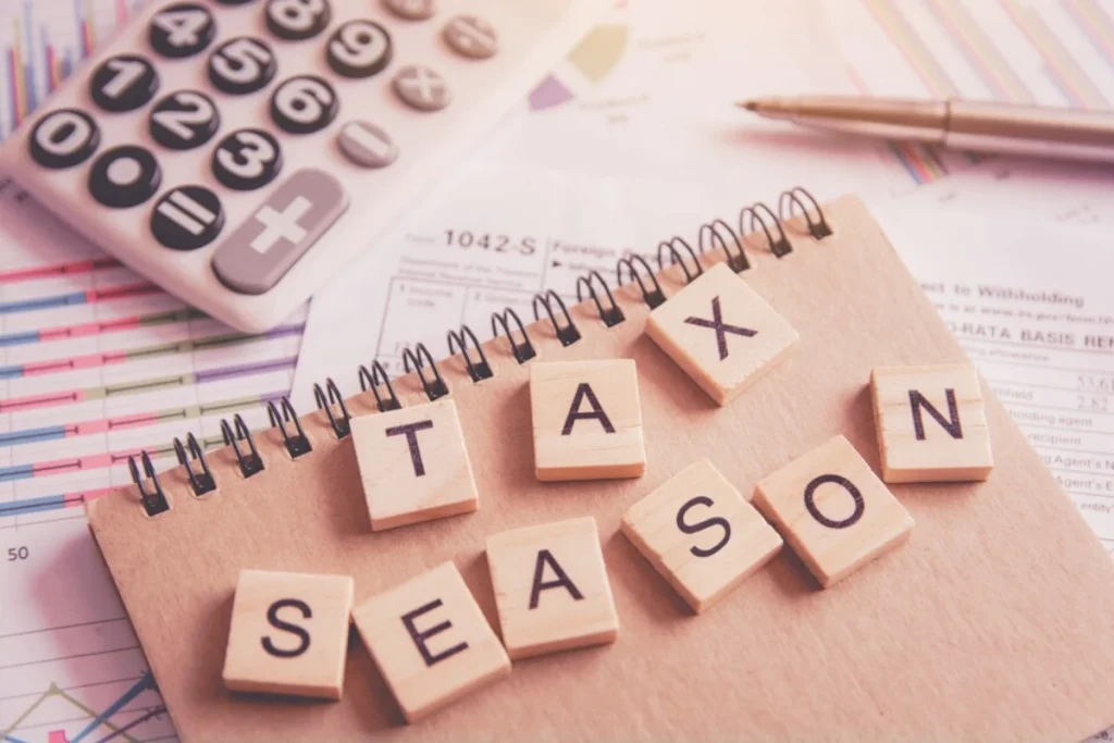 Letter wooden blocks tiles Tax season with on U.S. tax form

