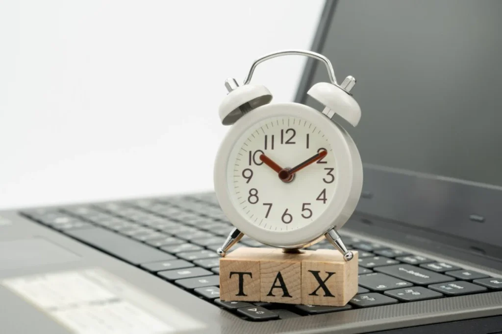 TAX Time watches put on the wood word TAX and white keyboard