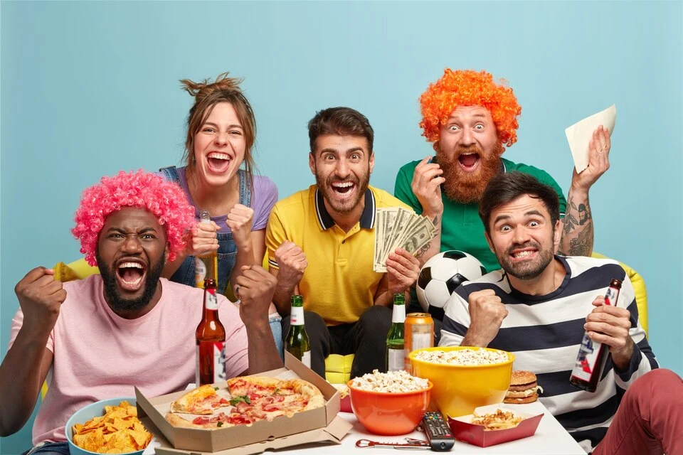 Friends betting on sports games in a happy atmosphere