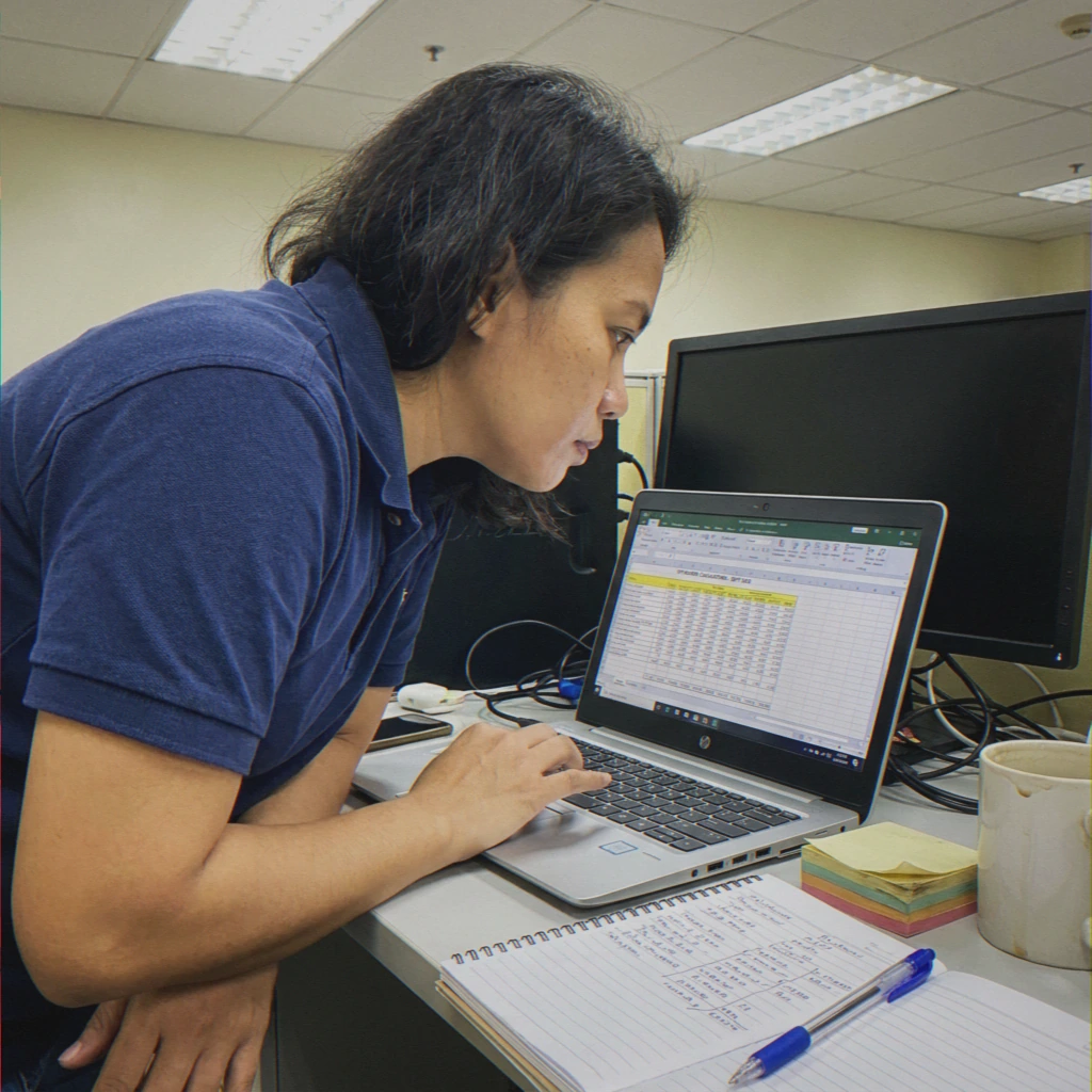 Southeast Asian woman typing on laptop at SCL Tax Services in the Bronx, NY. 10470