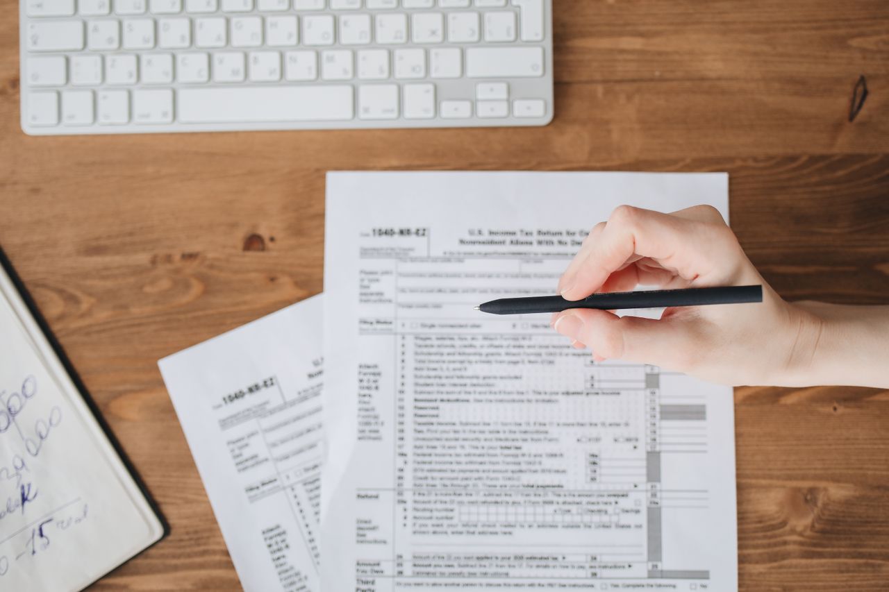 Person reviewing tax relief documents and checking for potential tax resolution scams